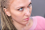 Attractive blond woman with soulful blue eyes looking up with a serious pensive expression in a close up cropped high angle portrait