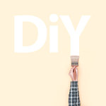 Decorator writing DIY on a wall using a brush, creativity and do it yourself concept