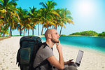 Explorer man plans a new travel to a tropical beach with his laptop