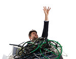 Businessman trapped by cables and computers. concept of stress and overwork