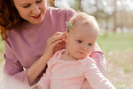 mom and daughter in the Park relax, mom found a beautiful flower and trying to try it on for the child, but she is not interested. Focus on child