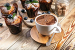 Muffins with blueberries and a cup of hot chocolate on a wooden background. homemade baking