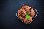 Bowl with scoops chocolate ice cream on a slate background