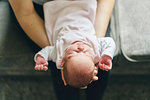 Mother supporting head of baby on lap