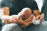 Father supporting head of baby on lap