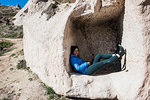 Woman lying down in cavern, Uchisar Castle, Göreme, Cappadocia, Nevsehir, Turkey