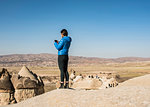 Woman taking photograph of fairy chimney, Göreme, Cappadocia, Nevsehir, Turkey
