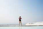 Woman looking down at thermal pool, Pamukkale, Denizli, Turkey