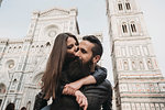 Couple playing piggyback ride and kissing, Santa Maria del Fiore, Firenze, Toscana, Italy