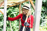 Mid adult woman constructing wooden shelter in her garden