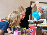 Girl and her sister baking a cake, weighing flour on kitchen scales