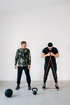 Fitness instructor teaching man using resistance band in studio