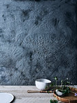 Ceramic bowls and plant against background of unfinished wall