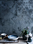 Ceramic bowls and vases against background of unfinished wall