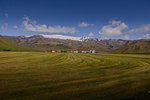 Landscape with distant row of houses and ice cap, Eyjafjallajökull, Iceland