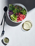 High key still life with tuna and quinoa poke bowl on white table, overhead view