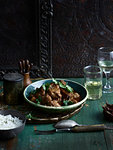 Rustic low key still life with bowl  of chettinad black pepper chicken fry and white wine on table