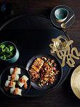 Rustic low key still life with dish of fungus cabbage roll and grilled whole squid on table, overhead view