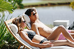 Young couple relaxing on deckchair by pond