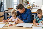 Parents helping children with homework at home