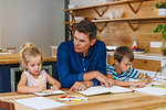 Father helping children with homework at home