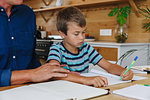 Father helping son with homework at home