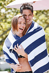 Couple wrapped in striped towel enjoying sun