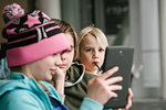 Girl and brothers looking at digital tablet in airport, head and shoulders