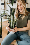 Woman carrying pot of house plant on lap