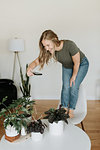 Woman taking photo of house plants with mobile phone