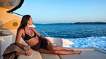 Woman in bikini relaxing on yacht