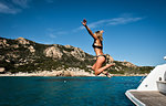 Woman jumping into sea from yacht, La Maddalena island, Sardegna, Italy