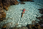 Woman in bikini enjoying clear sea water in lagoon, La Maddalena island, Sardegna, Italy