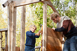 Father and son building treehouse together in garden