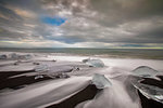 Long shutter of white rushing over melting icebergs, Jokulsarlon beach, Iceland