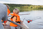 Adult sailing with boys on boat in lake, Finland