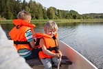 Adult sailing with boys on boat in lake, Finland