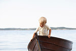 Boy playing in boat on beach