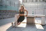 Young woman doing tricep dips on concrete bench