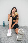 Young woman leaning against wall using smartphone