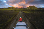 Woman traveller enjoying scenic view of volcanic mountains on vehicle, Landmannalaugar, Highlands, Iceland