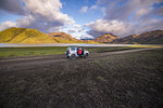 Woman traveller enjoying scenic view beside vehicle, Landmannalaugar, Highlands, Iceland