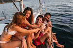 Friends toasting with champagne on sailboat, Italy