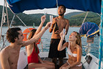 Friends toasting with champagne on sailboat, Italy