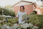 Woman working on plants and vegetables in her garden