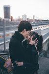 Young couple kissing in train station, Milan, Italy