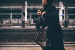 Young couple running on platform in train station, Milan, Italy