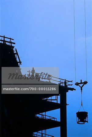 Silhouette of Worker and Construction Site at Sunset