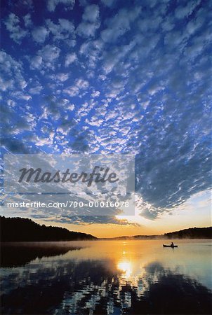 Man in Canoe on Lake Chandos At Sunset, Ontario, Canada