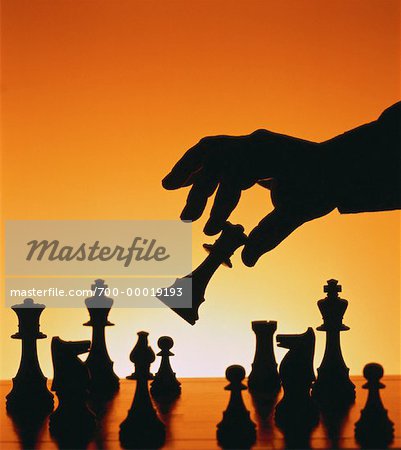 Silhouette of Hand Moving Chess Piece
